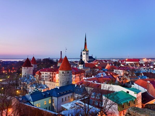 Tallinn Old Town roofs and spires above the Gulf of Finland at dusk
